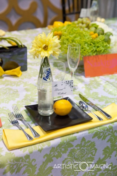 reception table with lemon and lime colors, black plates, Fanta bottle with daisies