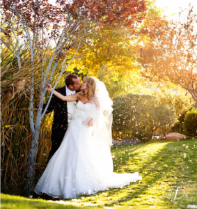 Bride and Groom kiss in autumn wedding