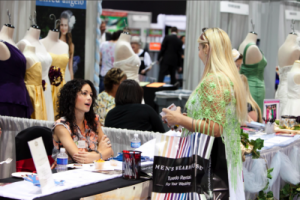 bride speaks to vendor at bridal show booth