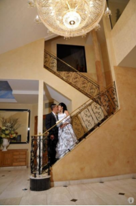 bride and groom on wrought-iron stair case